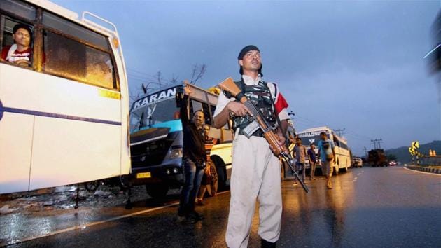 A paramilitary security personnel keeping vigil as a convoy of Amaranth pilgrims leave for Kashmir on the outskirts of Jammu on Tuesday(PTI)