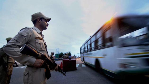 A security person stands guard as pilgrims leave for the Amarnath Yatra. At least seven pilgrims returning from the remote Himalayan shrine of Amarnath were shot dead and several wounded when militants opened fired on their bus as well as a security vehicle on Monday. (PTI)