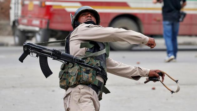 In retaliation a police officer throws a rock at stone pelters during disturbances in Srinagar. ‘Pellet guns are intended not to be lethal, but their use by India’s security forces has caused severe injuries and several deaths of bystanders, women and children among them,’ said one 25-year-old officer. (Cathal McNaughton / Reuters)