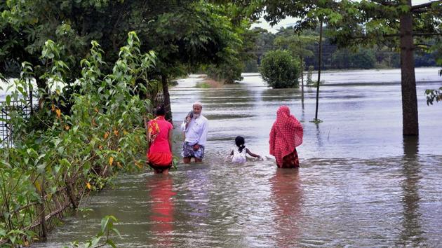 Villagers wade through a flooded street at Kureni Bori in Morigaon district of Assam. (PTI Photo) Villagers wade through a flooded street at Kureni Bori in Morigaon district of Assam. (PTI Photo)