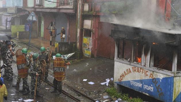 Policemen stand next to police station set alight during clashes with Gorkhaland supporters during an indefinite strike called Gorkha Janamukti Morcha (GJM), in Sonada near Darjeeling on July 8.(AFP Photo)
