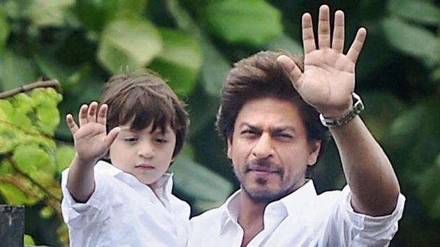 Bollywood actor Shah Rukh Khan along with son Abram greets his fans on the occasion of Eid at his residence in Mumbai on Monday.(PTI)