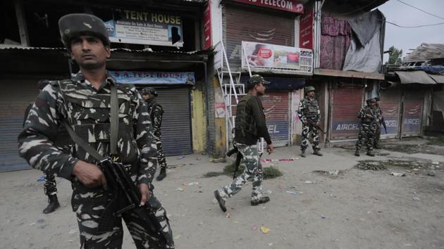 Security force personnel stand guard at the site of a militant attack in Batengo village, around 40 kilometers south of Srinagar.(HT Photo) Security force personnel stand guard at the site of a militant attack in Batengo village, around 40 kilometers south of Srinagar.(HT Photo)