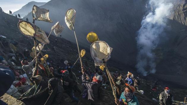 Members of the Tengger tribe who live around mount Bromo-Semeru volcano throw live offerings into the crater to honour Sang Hyang Widhi, and Mahadeva, the God of the mountain. (JUNI KRISWANTO / AFP) 