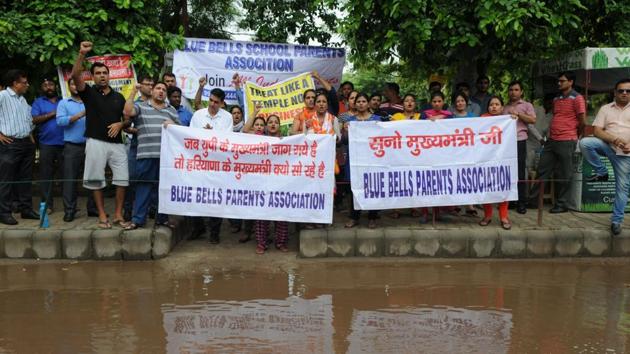 Parents of children studying in Blue Bells Model School in Sector 4 protest outside the school premises against development charges and increase in fee, on Wednesday.(Parveen Kumar/HT Photo)