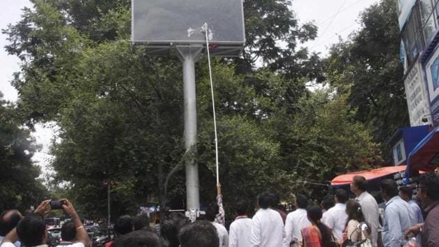 MNS activistis attacking an LED screen that has been eretced in the city.(HT PHOTO)
