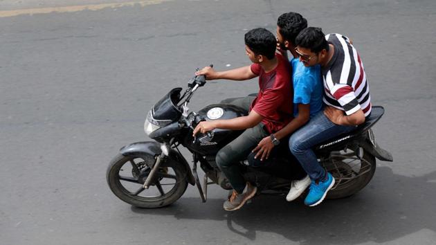 Three people travelling on a bike in Pune on Tuesday. This is a very common practise in the city and is a disaster waiting to happen. (HT PHOTO) Three people travelling on a bike in Pune on Tuesday. This is a very common practise in the city and is a disaster waiting to happen. (HT PHOTO)