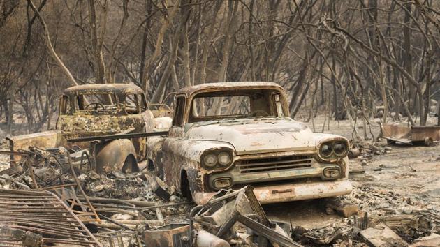 Trucks burned by a wildfire rest in a grove near Oroville, Calif. The fast-moving wildfire in the Sierra Nevada foothills destroyed structures, including homes, and led to several minor injuries, fire officials said. (Noah Berger / AP) 