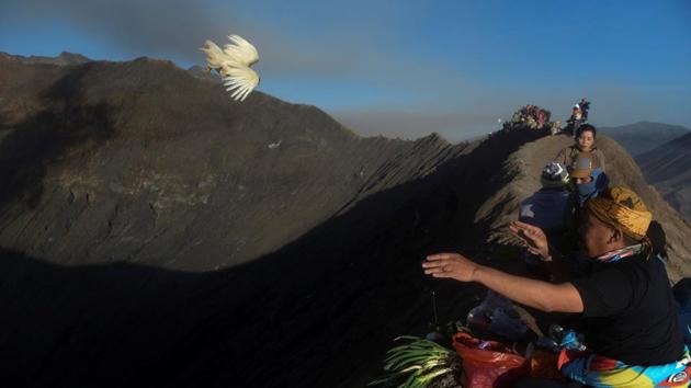 A villager throws a chicken towards the crater of Mount Bromo as an offering during the Kasada ceremony in Probolinggo, Indonesia. (Zabur Karuru / REUTERS) 