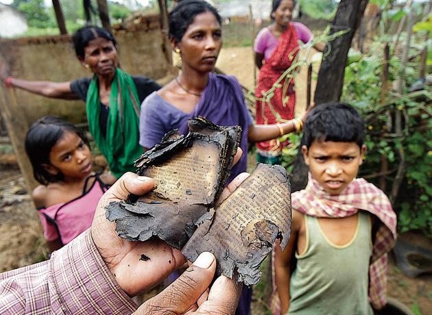Hari Chand Digal, a resident of Minia in Kandhamal District, holding up a burned Odia Bible in October 2008.(Vipin Kumar/HT)