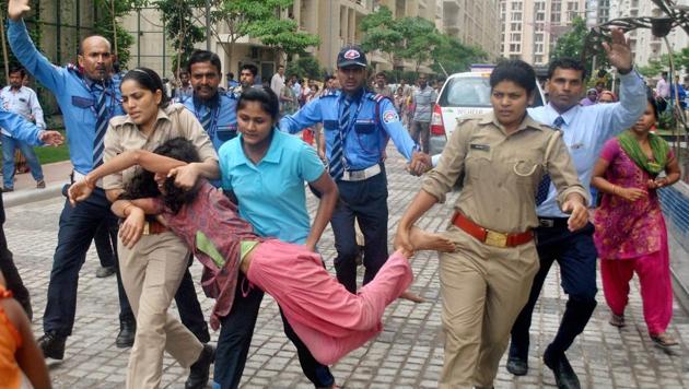 Police in action against local villagers who gathered at a housing society to protest after a domestic help was allegedly beaten by her employers on suspicion of theft, in Noida on Wednesday(PTI)