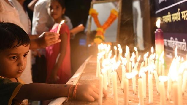 A child takes part in the candlelight vigil  at Parel. (Satyabrata Tripathy/HT PHOTO) 