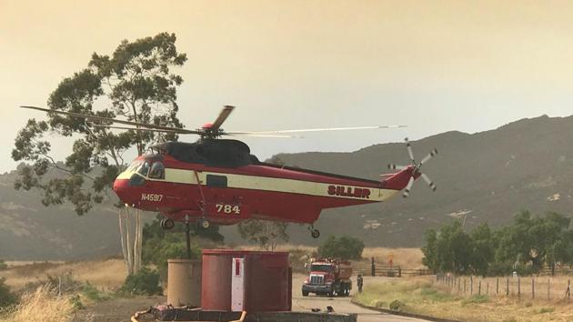 A helicopter loads fire retardent of the Whittier fire along Highway 154 near Santa Barbara. (Mike Eliason / REUTERS) 