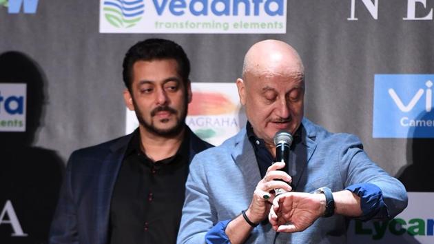 Salman Khan (L) looks on as Anupam Kher checks time during a press conference ahead of the 18th International Indian Film Academy (IIFA) Festival. (AFP)
