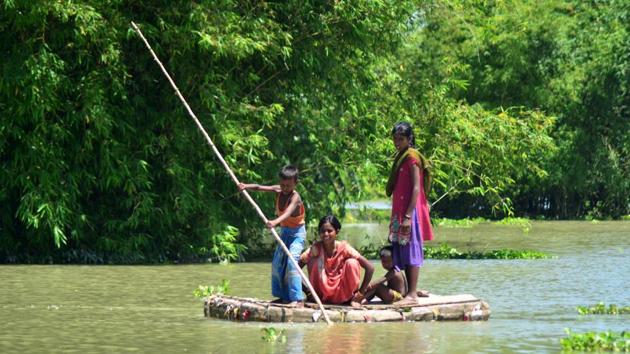 A boy travels with other family members on a homemade raft across flood waters in the Kamrup district of Assam. (AFP Photo) A boy travels with other family members on a homemade raft across flood waters in the Kamrup district of Assam. (AFP Photo)