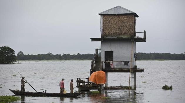 Indian forest officials leave for patrolling from their inundated watch tower in the flooded Kaziranga National Park. (Anupam Nath / AP)