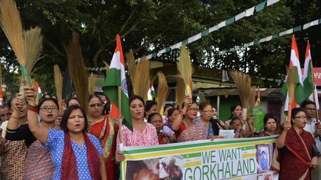 Women supporters of Gorkhaland movement chant slogans holding broomsticks at Sukna village in Darjeeling district on the outskirts of Siliguri on Friday.(AFP)