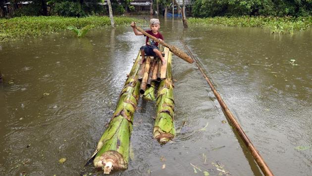 A boy rows a makeshift raft outside his submerged house in the flood-affected Kuthori village near Kaziranga National Park in Nagaon district, in the northeastern state of Assam, India. (Anuwar Hazarika / REUTERS)