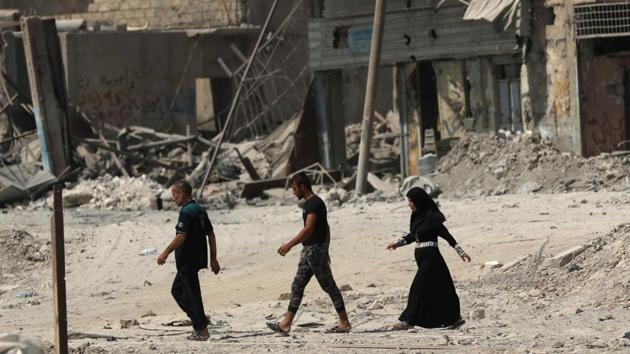 Iraqis walk on a damaged street in west Mosul on July 13, 2017, a few days after the government's announcement of the "liberation" of the embattled city from Islamic State (IS) group fighters.(AFP) Iraqis walk on a damaged street in west Mosul on July 13, 2017, a few days after the government's announcement of the "liberation" of the embattled city from Islamic State (IS) group fighters.(AFP)