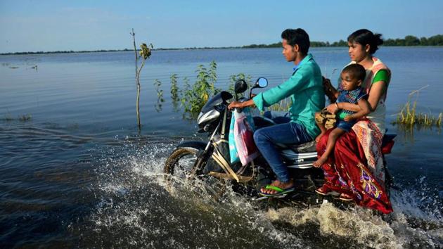A family travels on bike through a flooded road at Jamlai village in Kamrup district, Assam. The flood situation in the state has turned grave with the 17,43,119 people in 2,450 villages of 26 districts reeling under flood during the past 24 hours. (PTI) A family travels on bike through a flooded road at Jamlai village in Kamrup district, Assam. The flood situation in the state has turned grave with the 17,43,119 people in 2,450 villages of 26 districts reeling under flood during the past 24 hours. (PTI)