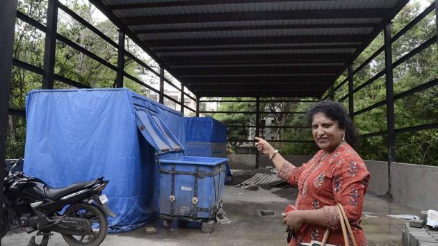 Maithili Manakwad, secretary, Wanowrie Residence Forum, points to the garbage processing unit on Salunkhe Vihar road.(HT PHOTO)