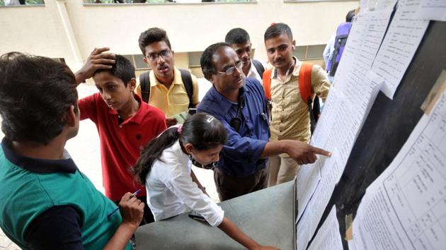 Students and parents check the short list for FYJC admission at Garware college in Pune.(HT PHOTO)