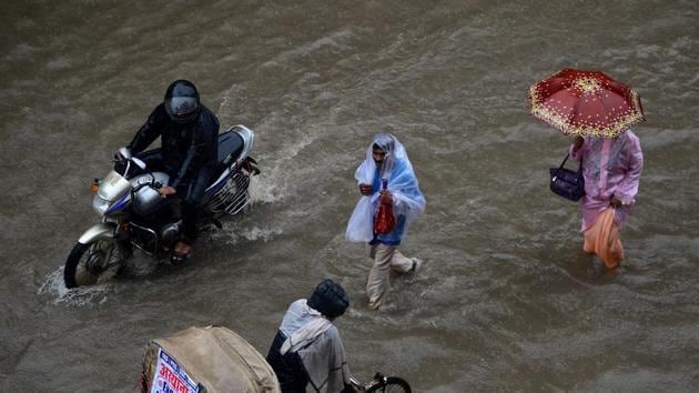 Indian commuters wade along a waterlogged street after heavy rains in Allahabad. (SANJAY KANOJIA / AFP) Indian commuters wade along a waterlogged street after heavy rains in Allahabad. (SANJAY KANOJIA / AFP)