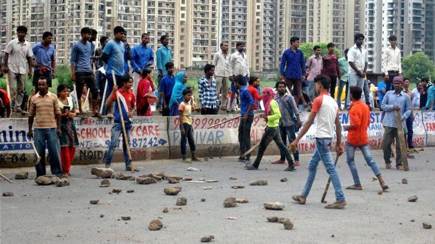Local villagers gather at a housing society to protest after a domestic help was allegedly beaten by her employers on suspicion of theft in Noida. (PTI) Local villagers gather at a housing society to protest after a domestic help was allegedly beaten by her employers on suspicion of theft in Noida. (PTI)