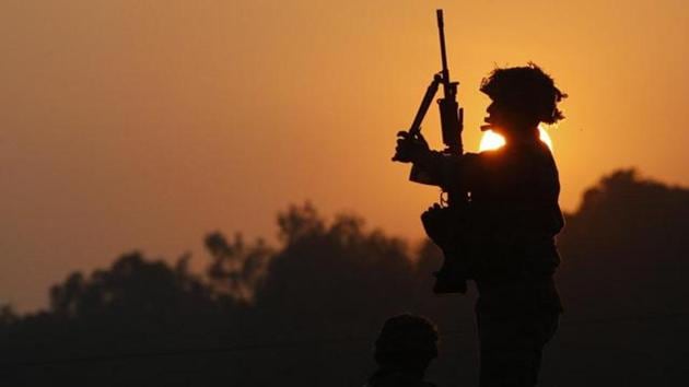 An Indian army soldier is silhouetted against the setting sun as he stands guard next to his colleague, outside the Indian air force base in Pathankot, India.(AP File Photo)