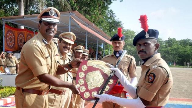 An SRPF cadet receives a trophy from Suresh Kumar Mekala during the their convocation in Pune. (HT PHOTO)