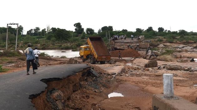 Indian labourers use heavy machinery to repair a flood damaged bridge over the River Bhogavo in the village of Aya in Surendranagar District, some 150kms from Ahmedabad. Heavy monsoon flooding has killed four people and alteast sicx others missing in the state of Gujarat, officials said on Sunday. (AFP) 