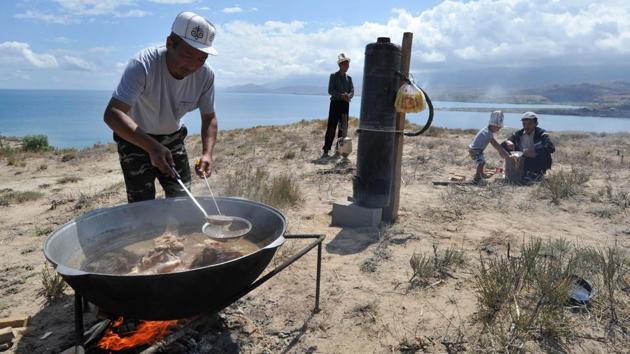A Kyrgyz man cooks traditional meals on an open fire. Samples of nomadic Kyrgyz cuisine such as Besh Barmak (lamb with noodles) , Boorsok and Ak Serke (Nomad’s soup) were presented as dietary samples of life in the steppes. (Vyacheslav Oseledko / AFP) A Kyrgyz man cooks traditional meals on an open fire. Samples of nomadic Kyrgyz cuisine such as Besh Barmak (lamb with noodles) , Boorsok and Ak Serke (Nomad’s soup) were presented as dietary samples of life in the steppes. (Vyacheslav Oseledko / AFP)
