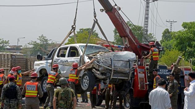 Pakistani officials use a crane to lift a security vehicle at the site of suicide bomb attack in Peshawar on July 17, 2017. A suicide bomber struck a vehicle carrying members of the paramilitary Frontier Corps, killing two and wounding six more in an attack claimed by the Taliban.(AFP)