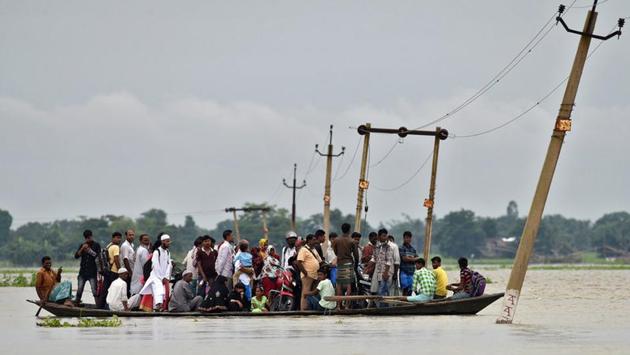 Villagers use a boat to cross a flooded road at Asigarh village in Morigaon district . Assam is the worst hit with 53 lives lost so far in floods and landslides with some 2 million people displaced. The overflowing Brahmaputra River has also completely marooned the Kaziranga wildlife sanctuary in Assam, forcing animals to flee to safer areas. (Anuwar Hazarika / REUTERS) 