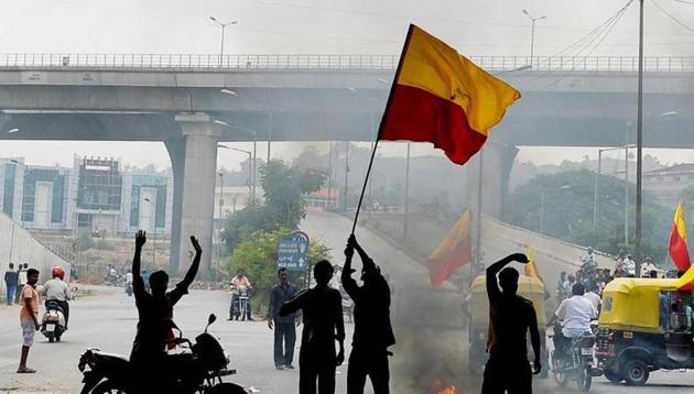 A file phot of activists in Bengaluru waving the Karnataka flag as they block traffic on a connecting road during a statewide strike over water shortage.(AFP)