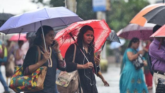 Officegoers in Vashi brave the rain to make it to work. (Satyabrata Tripathi/ht photo)