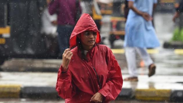 A woman walks through the rain in Mumbai on Tuesday. (SATYABRATA TRIPATHY/HT) A woman walks through the rain in Mumbai on Tuesday. (SATYABRATA TRIPATHY/HT)