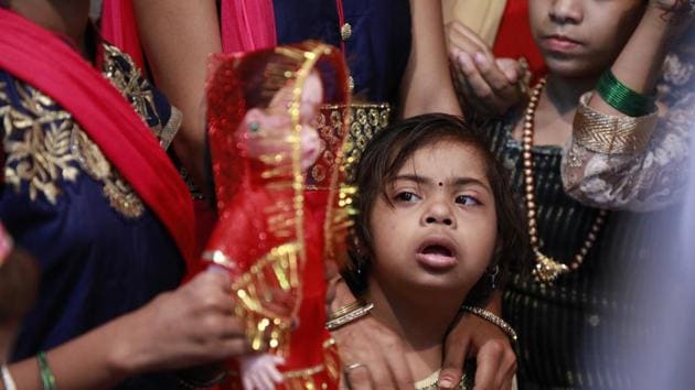 A girl looks at the ‘bride’ and her attire. (Rahul Raut/HT PHOTO) 