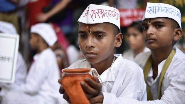 A boy holds the mortal remains of his father, who committed suicide, as he takes part in a joint protest of farmers at Jantar Mantar in New Delhi on July 19, 2017. Farmers from Gujarat, Haryana, Rajasthan, Maharashtra, Punjab and Uttar Pradesh have joined those from Tamil Nadu for a more forceful agitation.(Burhaan Kinu/HT Photo)