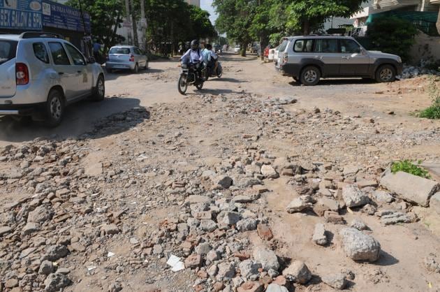 A broken road near Sushant Arcade in Sushant Lok-1. (Parveen Kumar/HT PHOTO) A broken road near Sushant Arcade in Sushant Lok-1. (Parveen Kumar/HT PHOTO)