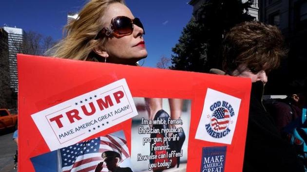 A supporter of President Donald Trump holds a sign at a "Spirit of America" rally in Denver. REUTERS/Rick Wilking/Files