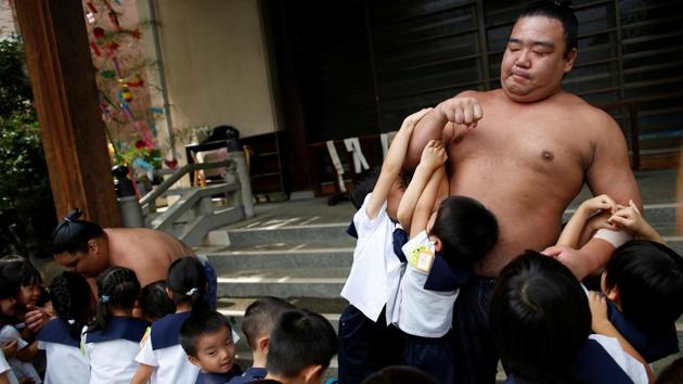 Sumo wrestler Kainoryu (R) plays with kindergarten children at Ganjoji Yakushido temple in Nagoya, Japan. After ending practice at 10:30 a.m., the wrestlers mingle with fans, sign autographs and pose for photos before the first of their two daily meals. (Issei Kato / REUTERS) Sumo wrestler Kainoryu (R) plays with kindergarten children at Ganjoji Yakushido temple in Nagoya, Japan. After ending practice at 10:30 a.m., the wrestlers mingle with fans, sign autographs and pose for photos before the first of their two daily meals. (Issei Kato / REUTERS)