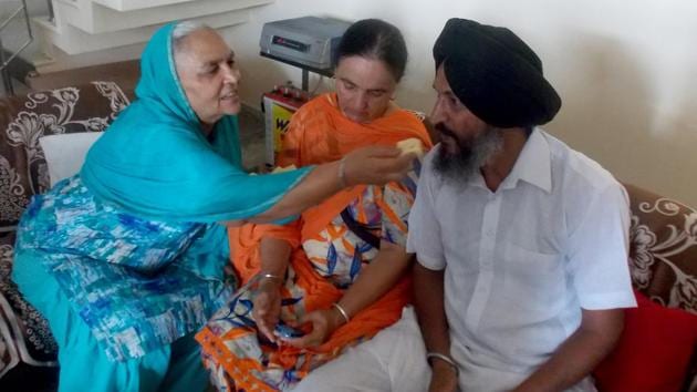 Harmanpreet's grandmother offering sweets to her father Harmandar Singh Bhullar on the all-rounder’s success. (HT Photo )