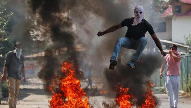 A man jumps over burning debris during protests in Srinagar. The Valley has been shaken by violent protests since July last year, leading to dozens of civilian deaths.(Reuters File Photo)