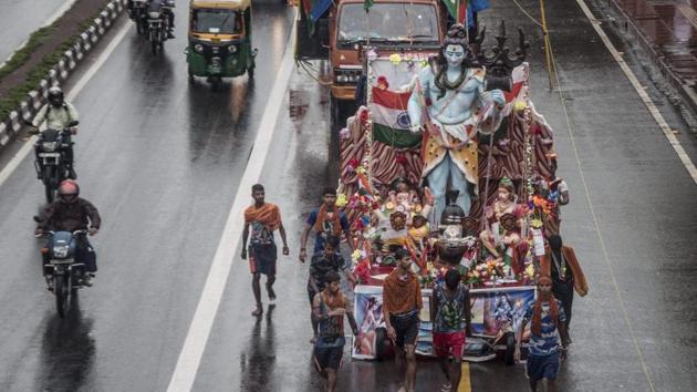 Millions of ‘Kanwarias’ from different states ,carry Kanwars on their shoulders, wearing orange dresses and walking hundreds of miles barefooted to bathe the ‘Shivaling’. (PTI)