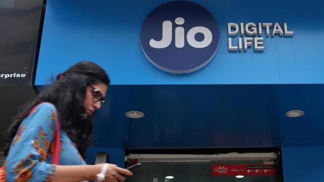 A woman checks her mobile phone as she walks past a mobile store of Reliance Industries' Jio telecoms unit in Mumbai.(Reuters File Photo)