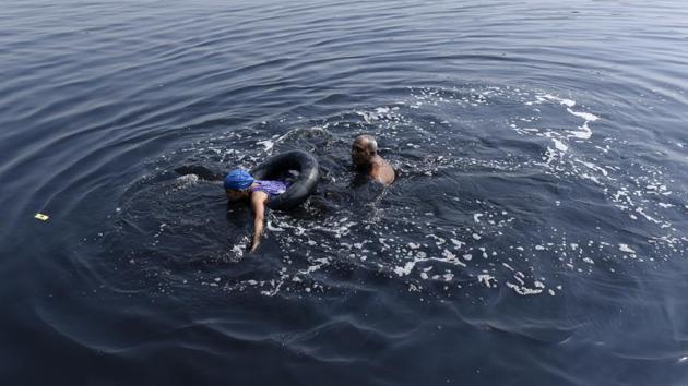 Despites the health risks of swimming in polluted waters these  young boys and girls are keen on  learn swimming in the Yamuna. High levels of ammonia, sewage and industrial waste are all pressing concerns on the health of this ancient river. (Saumya Khandelwal / HT Photo) 