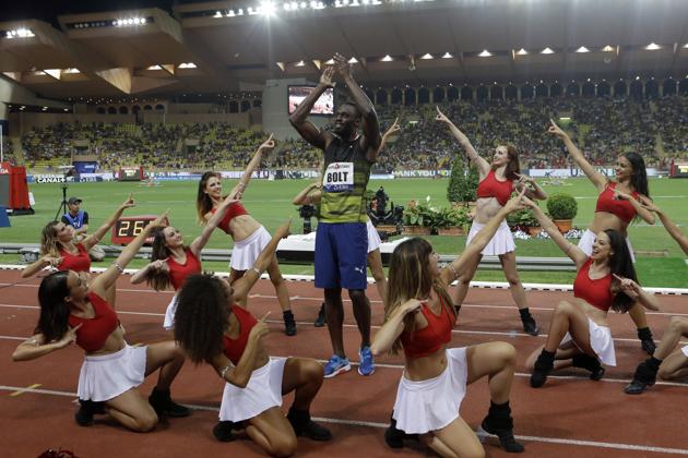 Usain Bolt acknowledges the crowd’s cheers whilst the pom-pom girls surround him. (AP) Usain Bolt acknowledges the crowd’s cheers whilst the pom-pom girls surround him. (AP)