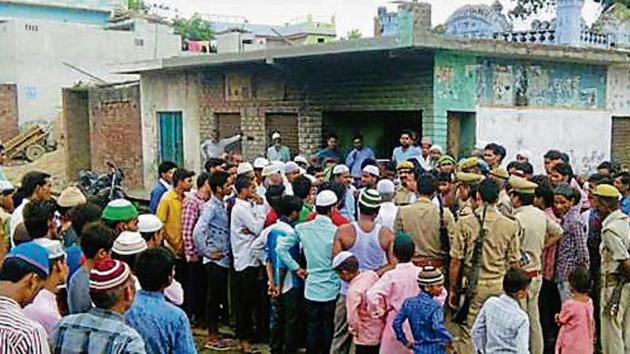 Policemen talk to a group of people in a village in Bareilly to figure out an alternate route for the yatra.(HT Photo)