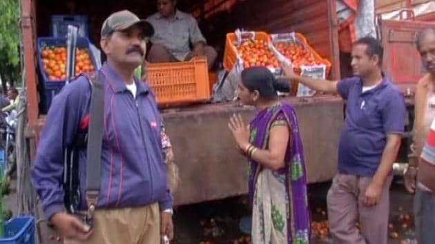 An armed guard stands by a tomato truck at the Indore vegetable market .(HT PHOTO)